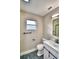 Modern bathroom features an updated vanity, mirror, light fixture and toilet, plus black and white tile floors at 7504 Willow Wisp E Dr, Lakeland, FL 33810