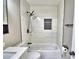 Modern bathroom with white tile tub/shower combo, a shower niche and black fixtures at 7504 Willow Wisp E Dr, Lakeland, FL 33810
