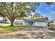 View of the house with blue exterior, white trim and a large tree in the front yard at 7504 Willow Wisp E Dr, Lakeland, FL 33810