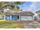 The front of the house shows a blue exterior with white trim, and a well-maintained lawn at 7504 Willow Wisp E Dr, Lakeland, FL 33810