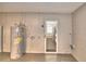 Showing the water heater, door to the backyard, and garage door at 7504 Willow Wisp E Dr, Lakeland, FL 33810