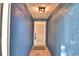 Hallway with textured blue walls, tile floors, and a white front door at 7504 Willow Wisp E Dr, Lakeland, FL 33810
