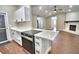 Open concept kitchen with stainless steel appliances and adjacent fireplace at 7504 Willow Wisp E Dr, Lakeland, FL 33810