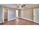 A spacious main bedroom features hardwood floors, ceiling fan, trim detail, and en suite bathroom and closet at 7504 Willow Wisp E Dr, Lakeland, FL 33810