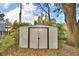 Exterior view of the metal shed on the property, framed by greenery and trees at 7504 Willow Wisp E Dr, Lakeland, FL 33810