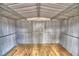 A clear and functional interior of a metal garden shed with a planked wooden floor at 7504 Willow Wisp E Dr, Lakeland, FL 33810