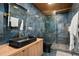 Unique bathroom with blue tile, wood-look cabinets, glass shower, and bronze hardware accents at 8131 Vineland Oaks Blvd, Orlando, FL 32835