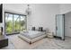Serene bedroom with a large window overlooking greenery, modern chandelier, and marble floors at 8131 Vineland Oaks Blvd, Orlando, FL 32835