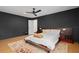 Dark-walled bedroom with a wooden bed frame, ceiling fan, and light wood flooring at 8131 Vineland Oaks Blvd, Orlando, FL 32835