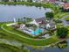 Aerial view of the community clubhouse, pool, playground, and surrounding lake at 8818 Bismarck Palm Dr, Winter Garden, FL 34787