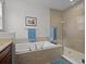 Bright bathroom with a soaking tub and a separate glass-enclosed shower at 8818 Bismarck Palm Dr, Winter Garden, FL 34787