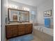 Bright bathroom with a soaking tub, double sinks, and a large mirror at 8818 Bismarck Palm Dr, Winter Garden, FL 34787