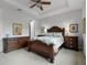 This primary bedroom is complete with a wooden bed frame, ceiling fan, and warm neutral tones at 8818 Bismarck Palm Dr, Winter Garden, FL 34787
