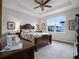 Comfortable bedroom with a decorative tray ceiling, large window and a plush, floral-patterned bed and bedding at 8818 Bismarck Palm Dr, Winter Garden, FL 34787