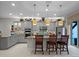 Modern kitchen featuring stainless steel appliances, granite countertops, gray cabinets, and an island with seating and pendant lights at 8818 Bismarck Palm Dr, Winter Garden, FL 34787