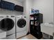 A well-equipped laundry room with a washer, dryer, utility sink, and storage at 8818 Bismarck Palm Dr, Winter Garden, FL 34787