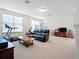 Spacious living room featuring a leather sofa, treadmill, and plenty of natural light at 8818 Bismarck Palm Dr, Winter Garden, FL 34787