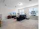 Bright living room with a large sofa, TV, and ample natural light from the windows at 8818 Bismarck Palm Dr, Winter Garden, FL 34787