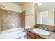 Bathroom showcasing a shower-tub combo, tile surround, vanity with granite countertop, and a large mirror at 909 Charo Pkwy # 1011, Davenport, FL 33897