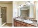 Bathroom featuring double sinks, granite countertops, and a large framed mirror at 909 Charo Pkwy # 1011, Davenport, FL 33897