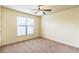 Bedroom with neutral carpet, ceiling fan, and window at 909 Charo Pkwy # 1011, Davenport, FL 33897