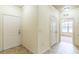 Hallway with neutral tile flooring, a front door, and access to other rooms at 909 Charo Pkwy # 1011, Davenport, FL 33897