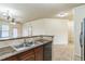 Open kitchen featuring a breakfast bar, stainless steel sink, granite countertops, and modern appliances at 909 Charo Pkwy # 1011, Davenport, FL 33897