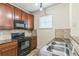 Updated kitchen featuring wood cabinets, black appliances and granite countertops at 909 Charo Pkwy # 1011, Davenport, FL 33897