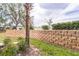 Landscaped yard featuring a stone privacy wall, bushes, and green space at 909 Charo Pkwy # 1011, Davenport, FL 33897