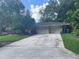 Two-car garage with a large driveway and mature trees enhances the curb appeal of this home at 955 Gamewell Ave, Maitland, FL 32751