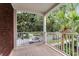 Cozy covered balcony with white railings and tiled flooring, offering views of lush greenery at 9670 Cypress Pine St, Orlando, FL 32827