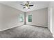 Spacious carpeted bedroom filled with natural light from two windows and featuring a ceiling fan at 9670 Cypress Pine St, Orlando, FL 32827