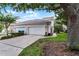 Attached two-car garage and driveway framed by mature trees and green lawn at 9670 Cypress Pine St, Orlando, FL 32827