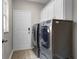 Laundry room features stainless steel washer and dryer plus white cabinets for storage at 9670 Cypress Pine St, Orlando, FL 32827