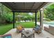 Expansive backyard featuring manicured lawn, lush landscaping, lounge chairs, and covered seating areas at 9743 Chestnut Ridge Dr, Windermere, FL 34786