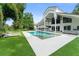 Wide angle of the backyard with pool, chairs, umbrella, and lush landscaping at 9743 Chestnut Ridge Dr, Windermere, FL 34786