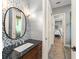 Bathroom with mosaic tiles, granite countertop, and a mirror adjacent to the shower and bedroom entry at 9743 Chestnut Ridge Dr, Windermere, FL 34786