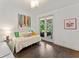 Bright bedroom with hardwood floors, modern artwork, and access to the screened in patio at 9743 Chestnut Ridge Dr, Windermere, FL 34786