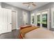 Bright bedroom featuring wood floors, ceiling fan, patio access and ensuite bathroom at 9743 Chestnut Ridge Dr, Windermere, FL 34786