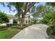 Elegant home with a brick driveway, lush greenery, and a large tree enhancing curb appeal at 9743 Chestnut Ridge Dr, Windermere, FL 34786
