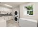 Bright laundry room features updated appliances, cabinetry, mosaic backsplash, and a large window at 9743 Chestnut Ridge Dr, Windermere, FL 34786