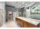 Main bathroom featuring granite countertops with double sinks, a glass shower and a walk-in closet at 9743 Chestnut Ridge Dr, Windermere, FL 34786