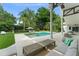 Covered patio features seating area overlooking pool, lush landscaping, and tropical foliage at 9743 Chestnut Ridge Dr, Windermere, FL 34786