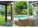 Covered patio with view of pool, manicured lawn, lush landscaping, and mature trees at 9743 Chestnut Ridge Dr, Windermere, FL 34786