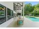 Covered patio features outdoor dining area overlooking backyard, pool, and lush landscaping at 9743 Chestnut Ridge Dr, Windermere, FL 34786