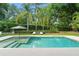 Backyard pool with lounge chairs and umbrella is surrounded by lush greenery at 9743 Chestnut Ridge Dr, Windermere, FL 34786