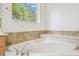Close up on a soaking tub with tile backsplash and chrome fixtures at 10080 Cove Lake Dr, Orlando, FL 32836