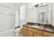 Well-lit bathroom showcasing a granite vanity, large mirror, and shower-tub combo at 10080 Cove Lake Dr, Orlando, FL 32836