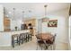 Well-lit dining area seamlessly blends with the kitchen, showcasing granite countertops and modern lighting at 10080 Cove Lake Dr, Orlando, FL 32836
