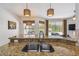 An open kitchen boasts a stainless steel sink and granite countertops overlooking the patio at 10080 Cove Lake Dr, Orlando, FL 32836